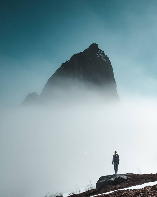 Man standing and looking at a mountain peak